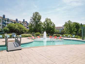 commmons pool with chairs and water fountain at The Crest at Sugarloaf Apartments, Lawrenceville , Georgia